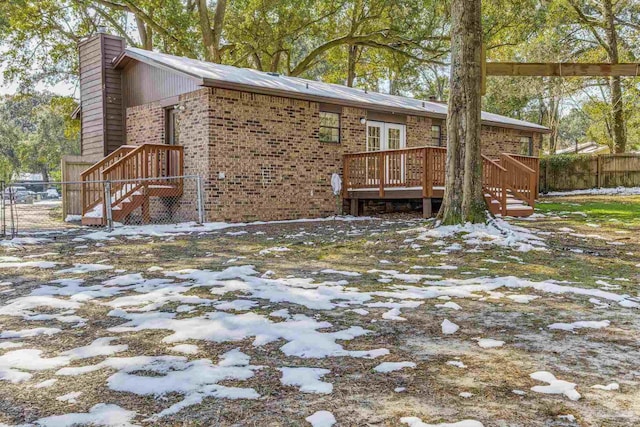 snow covered house featuring a wooden deck