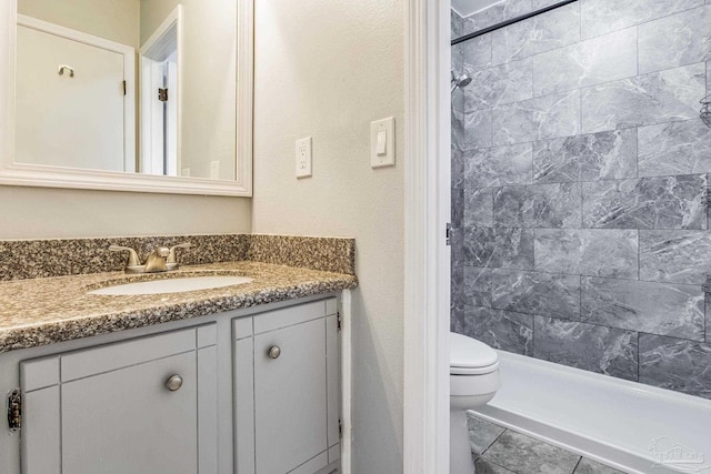 bathroom featuring a shower, vanity, and toilet