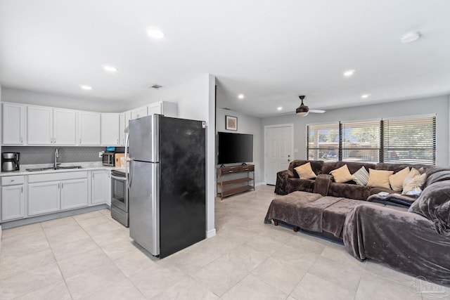 kitchen with white cabinetry, sink, backsplash, ceiling fan, and stainless steel appliances