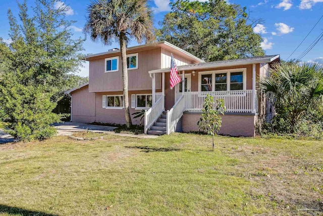 back of property with a yard and covered porch