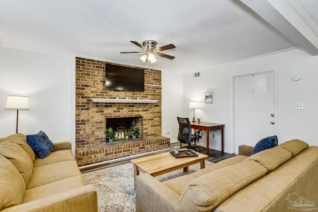 living room with hardwood / wood-style floors, crown molding, a textured ceiling, a brick fireplace, and ceiling fan