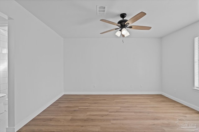 empty room with ceiling fan and light hardwood / wood-style flooring