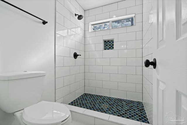 bathroom with toilet and a tile shower