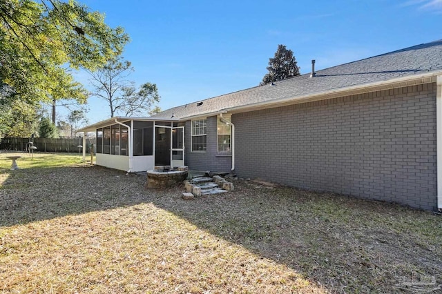 back of house with a sunroom and a lawn