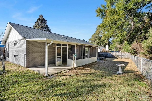 rear view of house with a patio area, a sunroom, and a yard