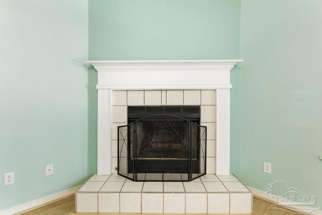 room details with wood finished floors, a fireplace, and baseboards