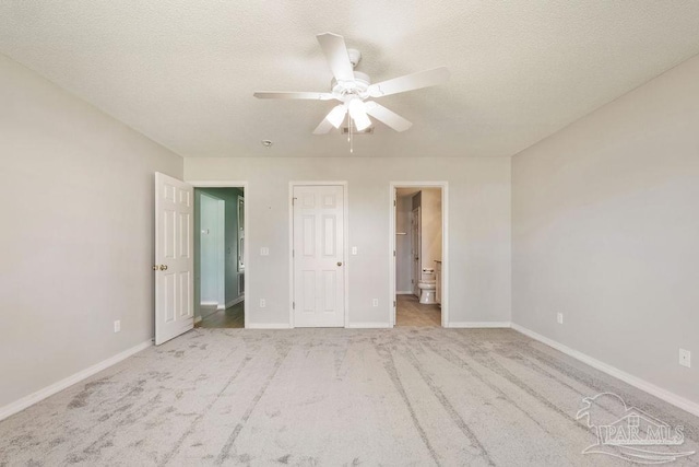 unfurnished bedroom featuring carpet, baseboards, and a textured ceiling