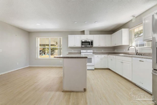 kitchen with light wood finished floors, white appliances, and a wealth of natural light