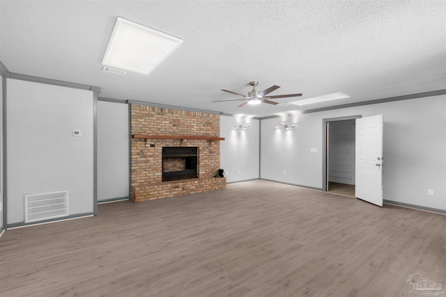 4881 Calvin Dr, Milton, FL 32583 - unfurnished living room featuring ceiling fan, a textured ceiling, wood finished floors, baseboards, and crown molding