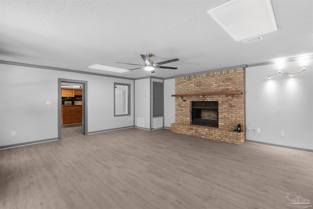 4881 Calvin Dr, Milton, FL 32583 - unfurnished living room featuring wood finished floors, a textured ceiling, ornamental molding, a fireplace, and a ceiling fan