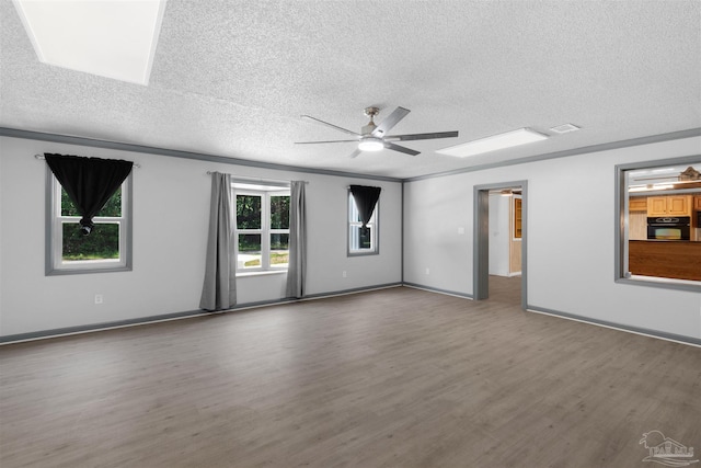 4881 Calvin Dr, Milton, FL 32583 - unfurnished room featuring a textured ceiling, wood finished floors, a ceiling fan, baseboards, and a skylight