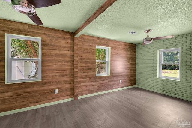 4881 Calvin Dr, Milton, FL 32583 - spare room with a textured ceiling, ceiling fan, wood finished floors, baseboards, and wood walls