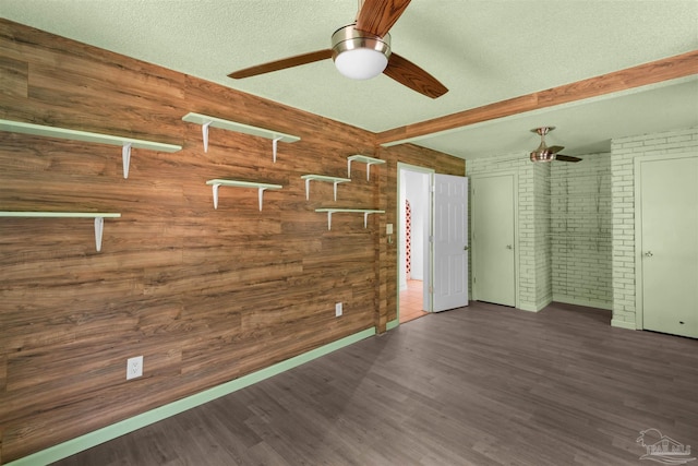 4881 Calvin Dr, Milton, FL 32583 - empty room with a ceiling fan, wood walls, wood finished floors, brick wall, and a textured ceiling