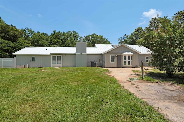4881 Calvin Dr, Milton, FL 32583 - back of house with a chimney, metal roof, and cooling unit