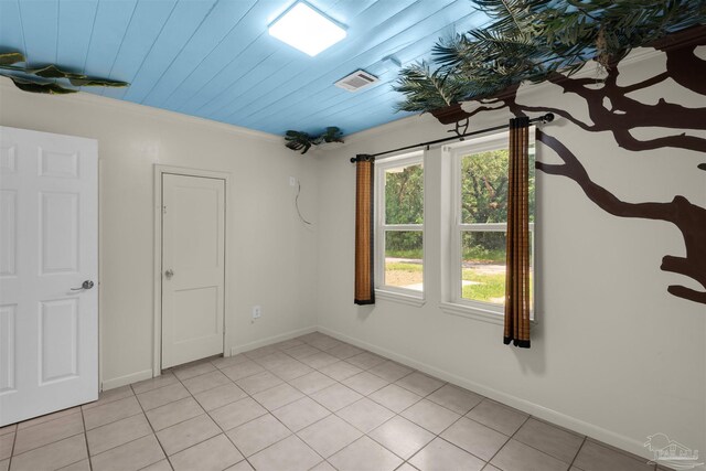 4881 Calvin Dr, Milton, FL 32583 - empty room with light tile patterned floors, baseboards, and crown molding