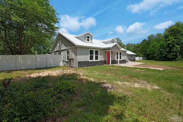4881 Calvin Dr, Milton, FL 32583 - rear view of house featuring stone siding, a patio area, and metal roof