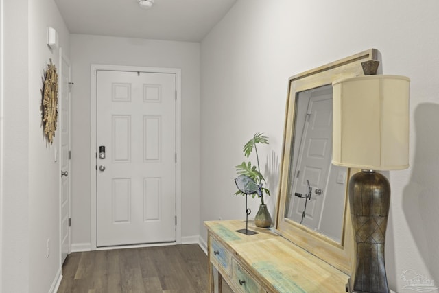 entryway with dark wood finished floors and baseboards