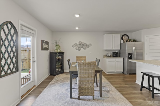 dining space with dark wood-type flooring, a wealth of natural light, and recessed lighting