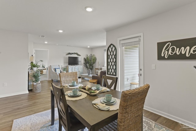 dining area featuring visible vents, baseboards, wood finished floors, and recessed lighting