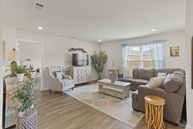 living area with baseboards, visible vents, wood finished floors, and recessed lighting