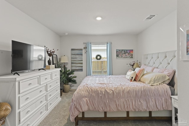 bedroom featuring visible vents and light colored carpet