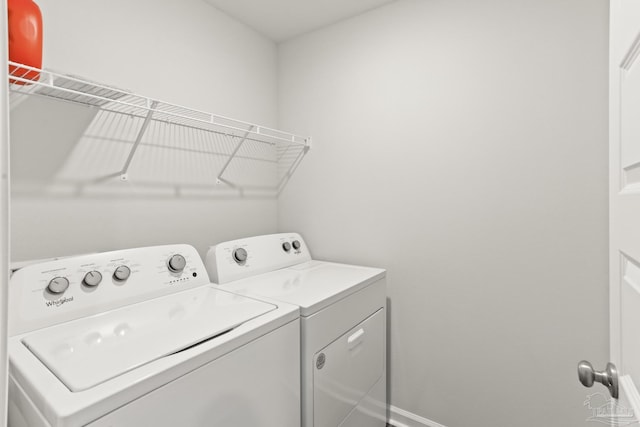 laundry area with laundry area, baseboards, and separate washer and dryer