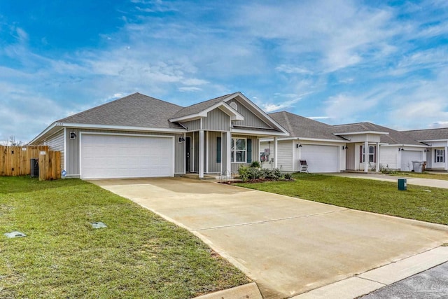 ranch-style house featuring a front yard, driveway, an attached garage, and fence