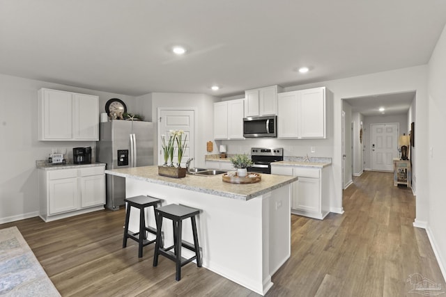 kitchen with light countertops, appliances with stainless steel finishes, a sink, and white cabinetry