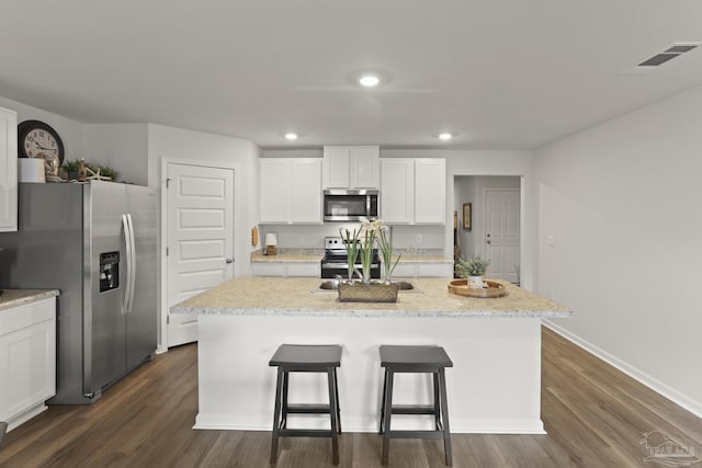 kitchen with stainless steel appliances, dark wood-style flooring, a sink, visible vents, and white cabinets