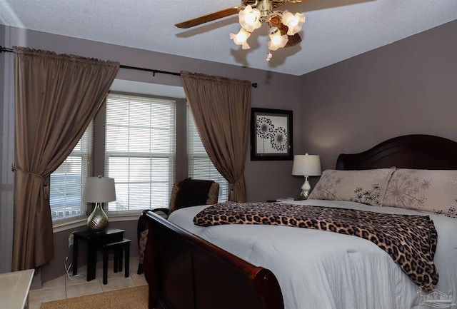 tiled bedroom featuring ceiling fan and a textured ceiling