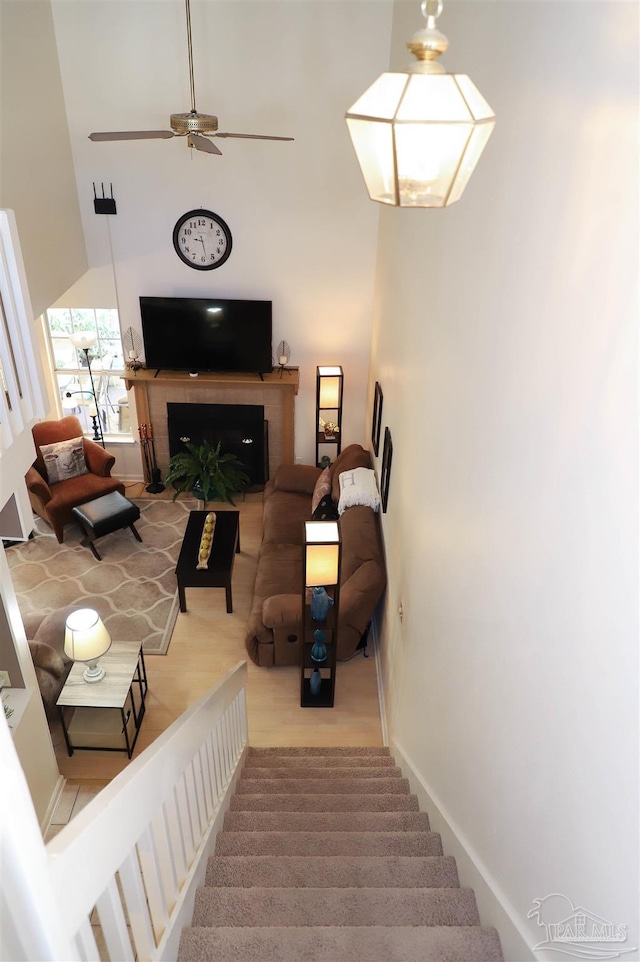 living room featuring ceiling fan and a towering ceiling