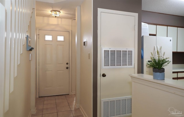 doorway featuring a textured ceiling and light tile patterned floors