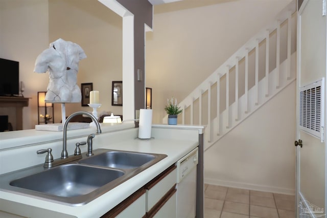 kitchen with light tile patterned flooring, sink, white cabinetry, dishwasher, and kitchen peninsula