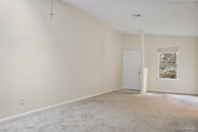 carpeted spare room with lofted ceiling