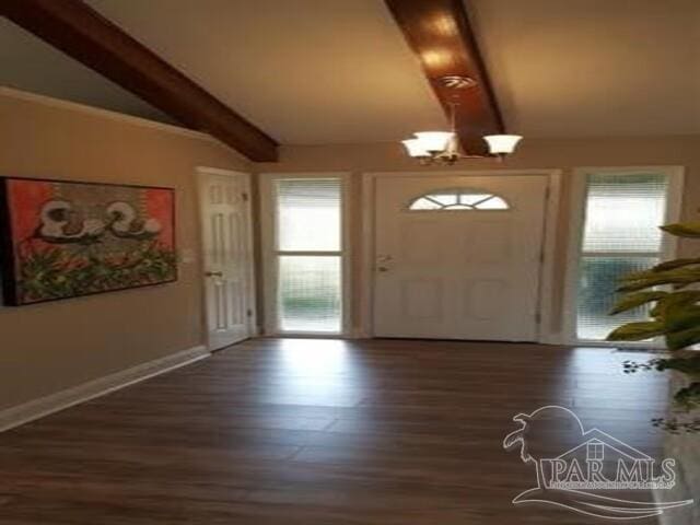 entrance foyer featuring vaulted ceiling with beams, a wealth of natural light, dark wood-type flooring, and a notable chandelier