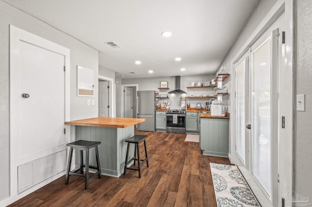 4684 Evelyn St, Pace, FL 32571 - kitchen with butcher block countertops, wall chimney range hood, stainless steel appliances, open shelves, and dark wood-style flooring