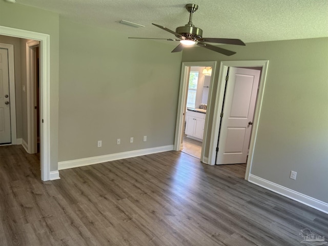 spare room with a textured ceiling, ceiling fan, and wood-type flooring