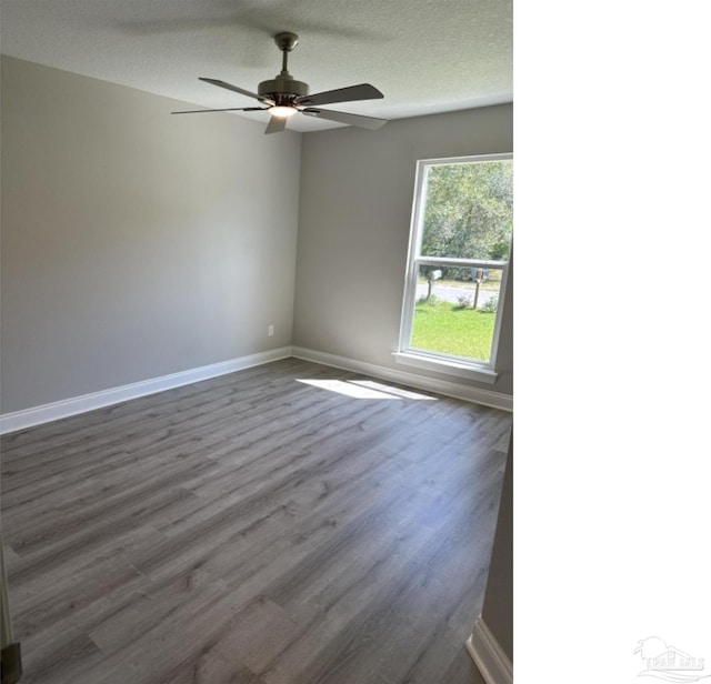 spare room with ceiling fan, a textured ceiling, and hardwood / wood-style flooring