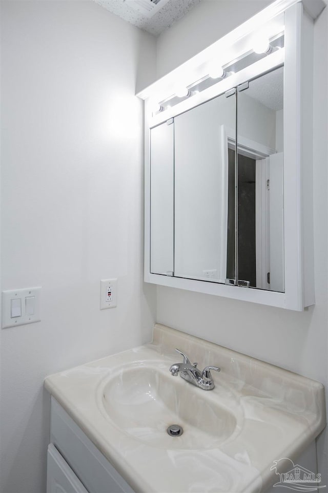 bathroom with vanity and a textured ceiling