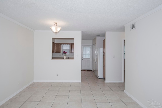 interior space featuring light tile patterned flooring, crown molding, and a textured ceiling