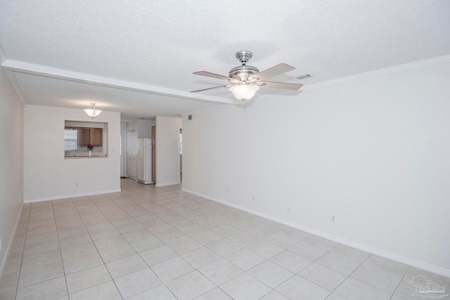 spare room with ornamental molding, ceiling fan, light tile patterned floors, and a textured ceiling