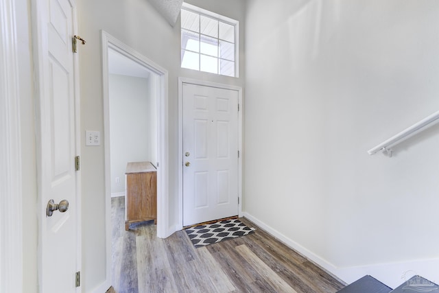 foyer featuring baseboards and wood finished floors