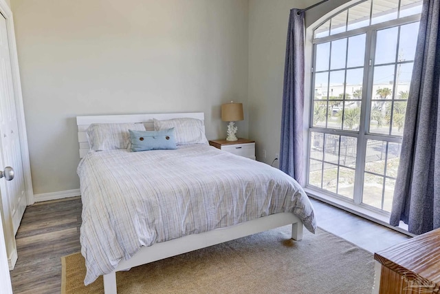 bedroom with baseboards and wood finished floors