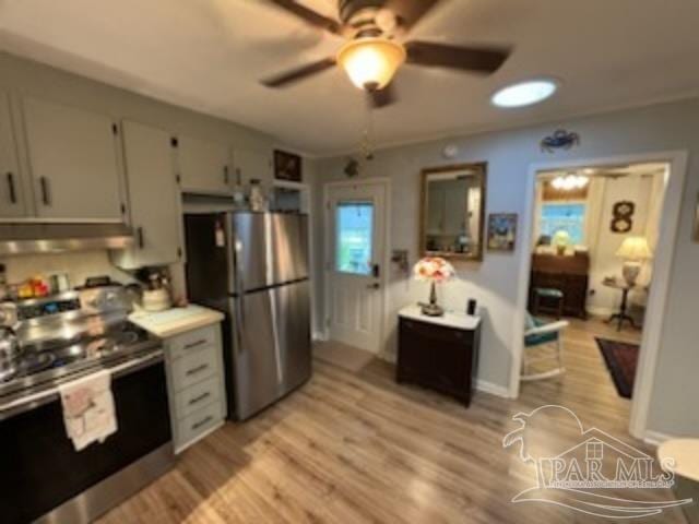 kitchen with appliances with stainless steel finishes, light hardwood / wood-style floors, white cabinetry, and ceiling fan