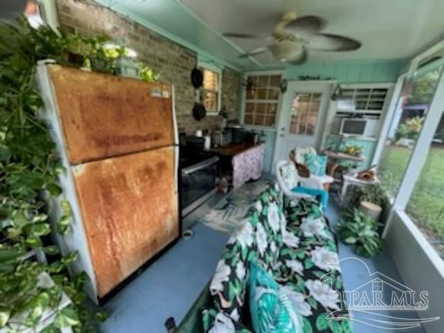 sunroom / solarium featuring ceiling fan