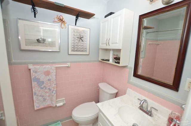 bathroom with vanity, tile walls, and toilet