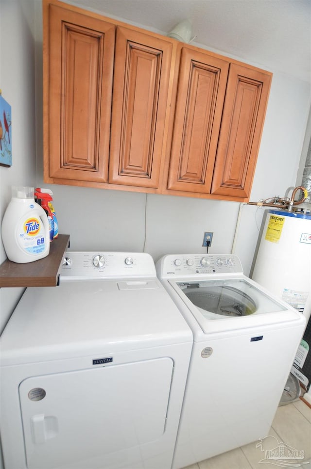 washroom featuring separate washer and dryer, light tile patterned floors, cabinets, and gas water heater