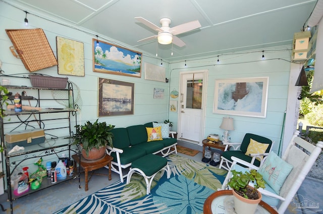 sitting room featuring concrete flooring and ceiling fan