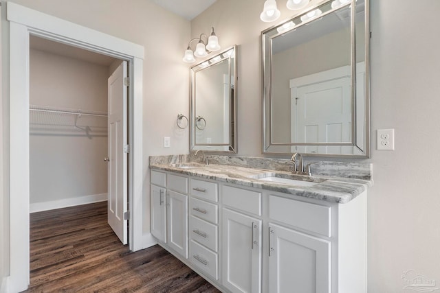 2748 Woodman Loop, Cantonment, FL 32533 - full bath with wood finished floors, double vanity, a spacious closet, and baseboards