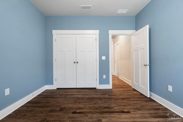 2748 Woodman Loop, Cantonment, FL 32533 - unfurnished bedroom featuring dark wood-style floors, baseboards, and a closet